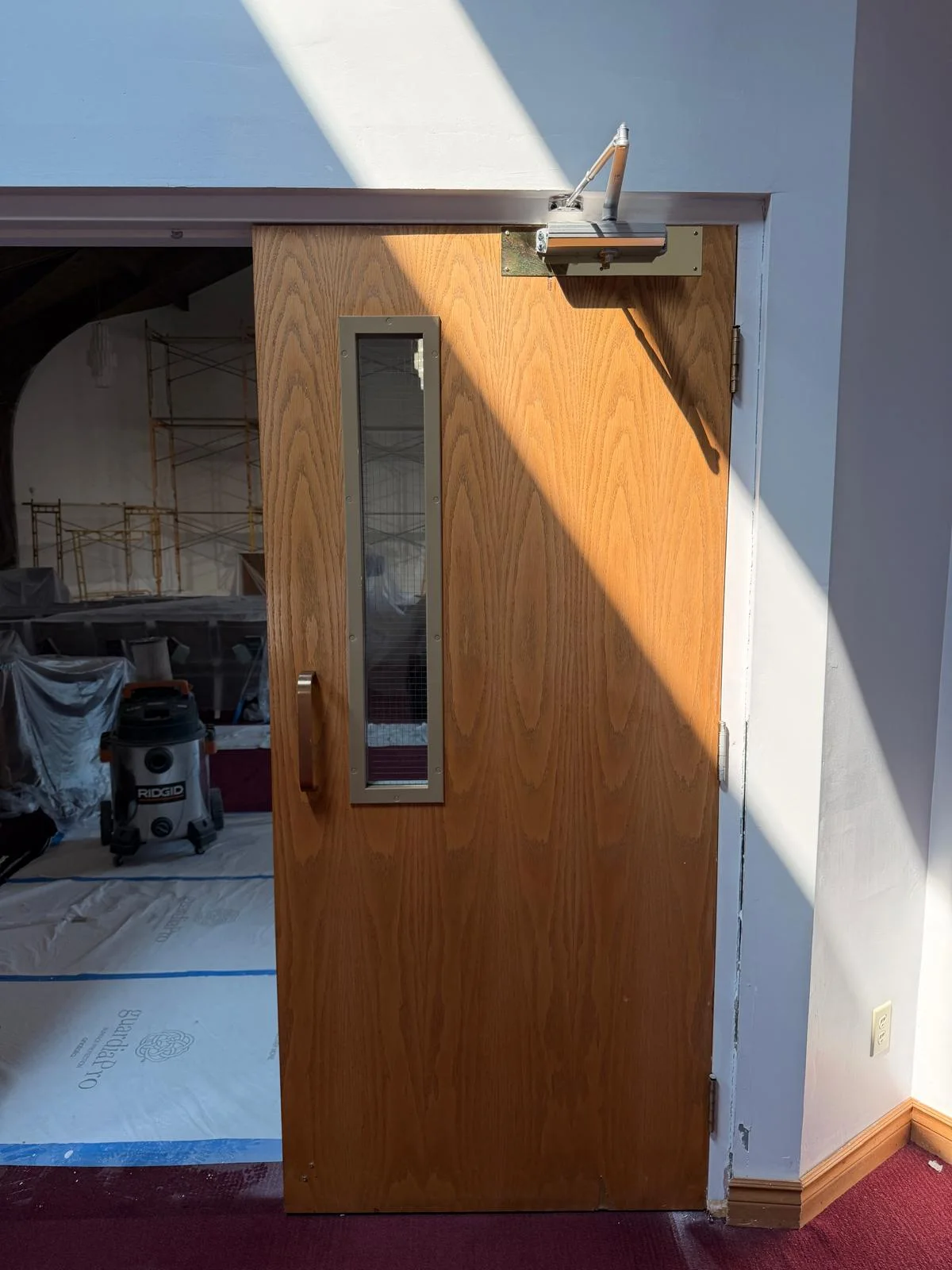 Overhead closer and arm on a commercial door