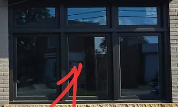 Detail of the central storefront glazing and frame, retaining the customer’s original annotation.